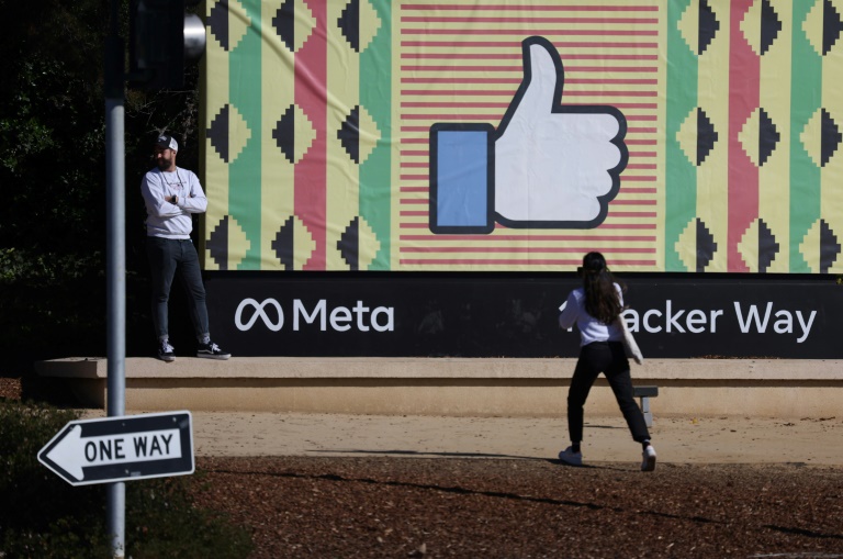 A person walks past a sign near Meta headquarters in Menlo Park, California