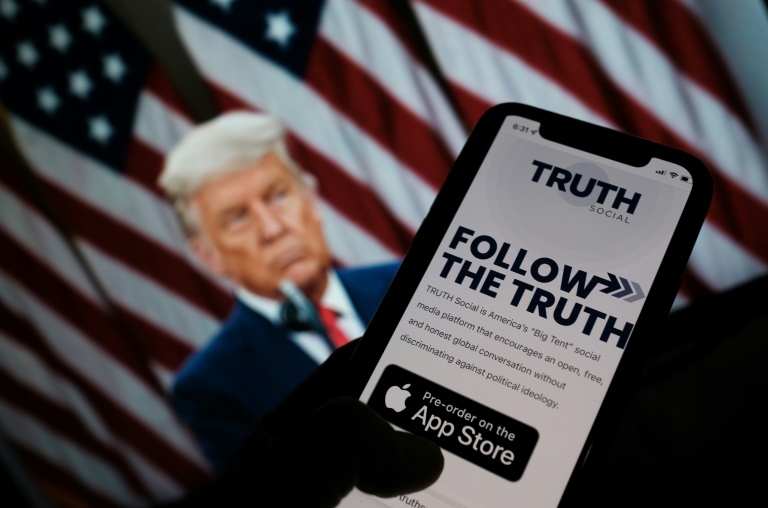 Donald Trump's new 'Truth Social' app is seen on a smartphone screen before a picture of the former president