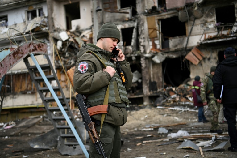 A Ukrainian serviceman talks on a smartphone in a Kyiv suburb on February 25