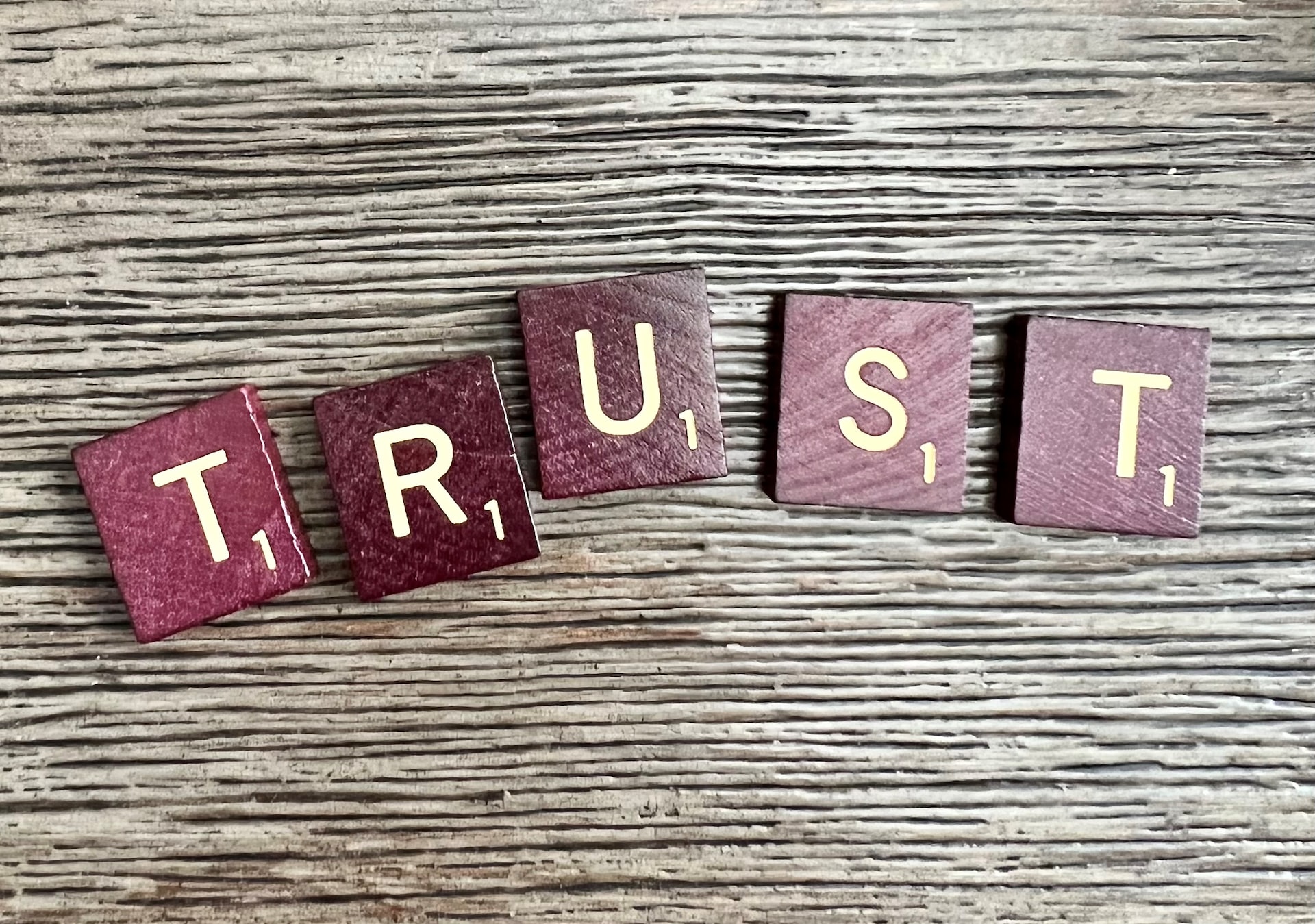 Scrabble tiles spelling 'trust'