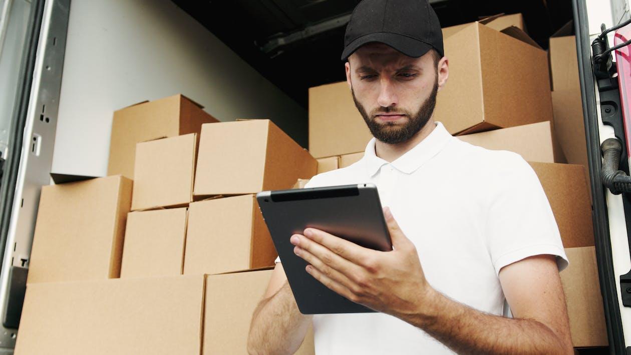 Free Man in White Polo Shirt Using a Tablet Computer Stock Photo