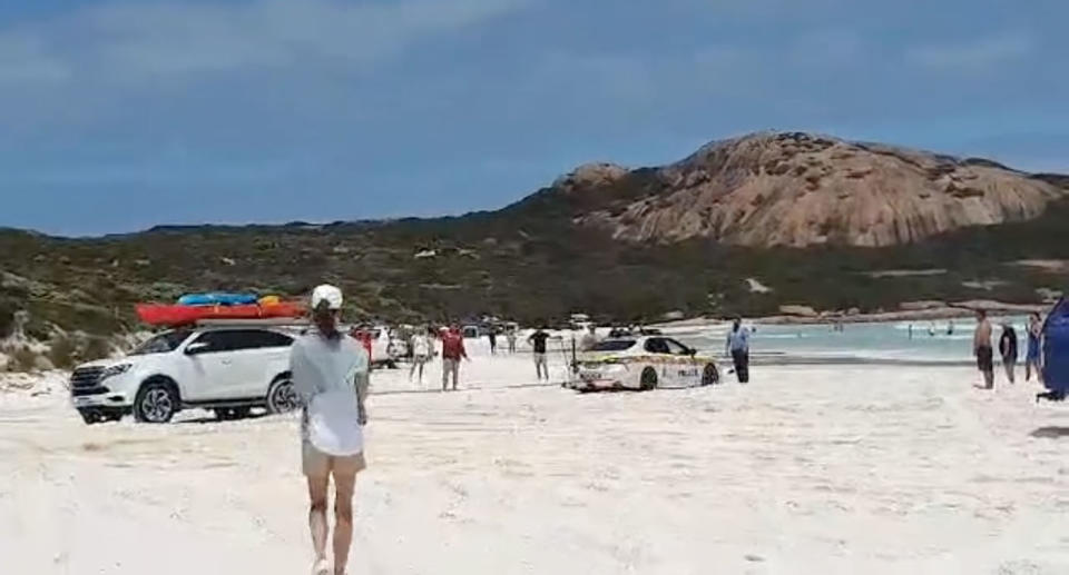 A beachgoer in a white 4WD helped tow the police car off the sand.