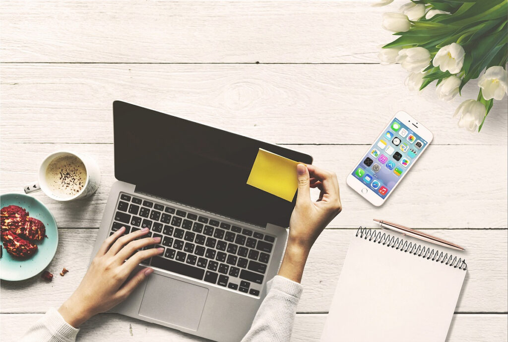 woman's hands, laptop, cup of coffee, food on a plate - use for copywriting