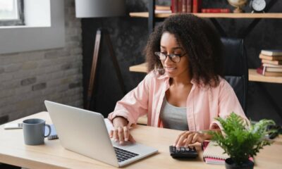 how to make money fast as a woman - Young businesswoman freelancer counting her income at a desk