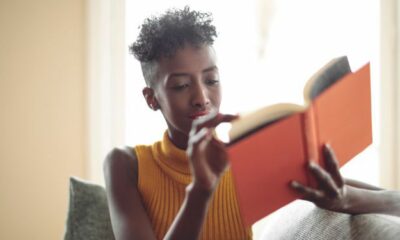 Image of a Black person reading an orange book