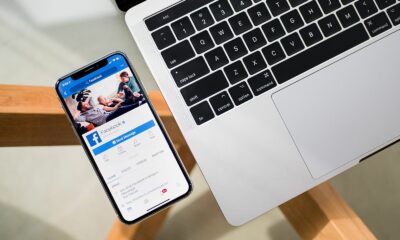 Facebook on iPhone with laptop