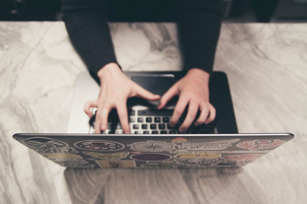 A picture of a person typing on a laptop.