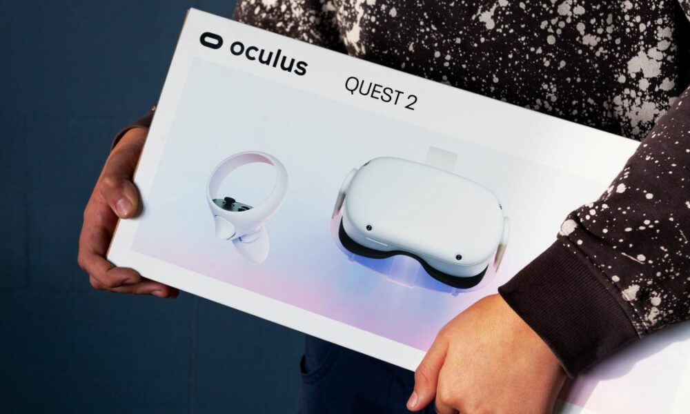 A person carrying a box with an Oculus Quest 2 VR headset in