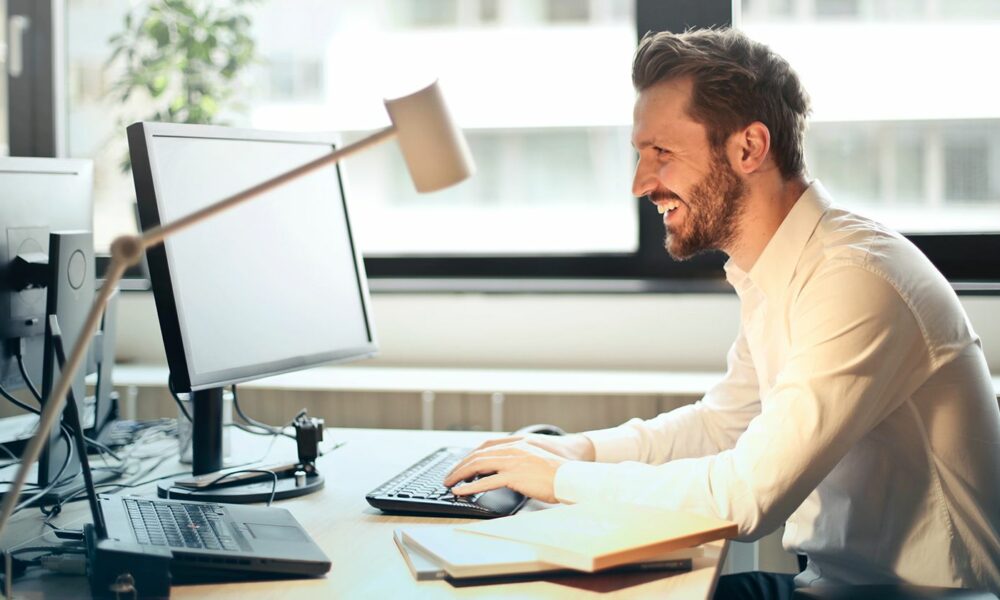 Man working on computer and smiling