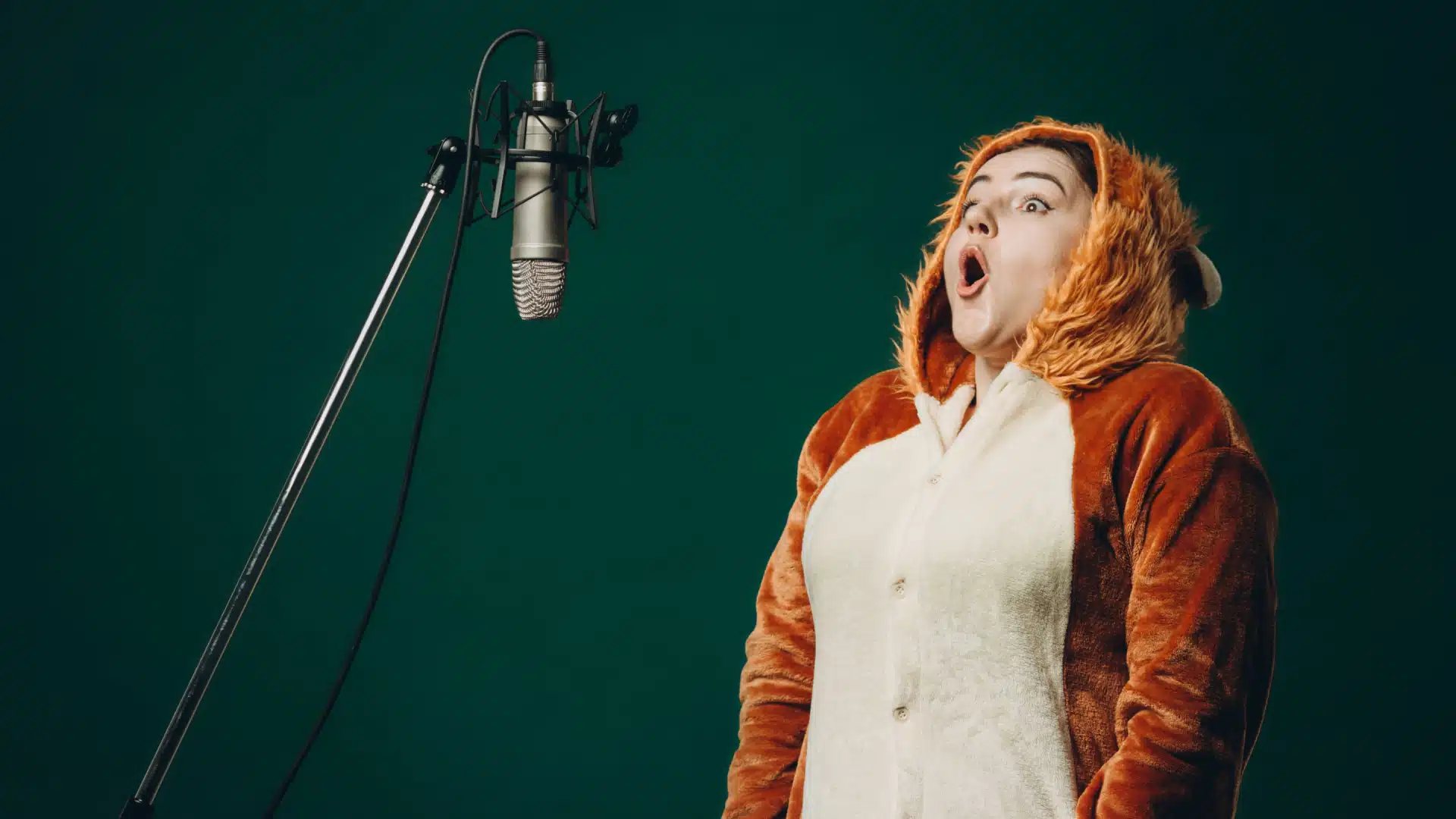 A woman dressed in a bear suit stands in front of a microphone ready to shout. 