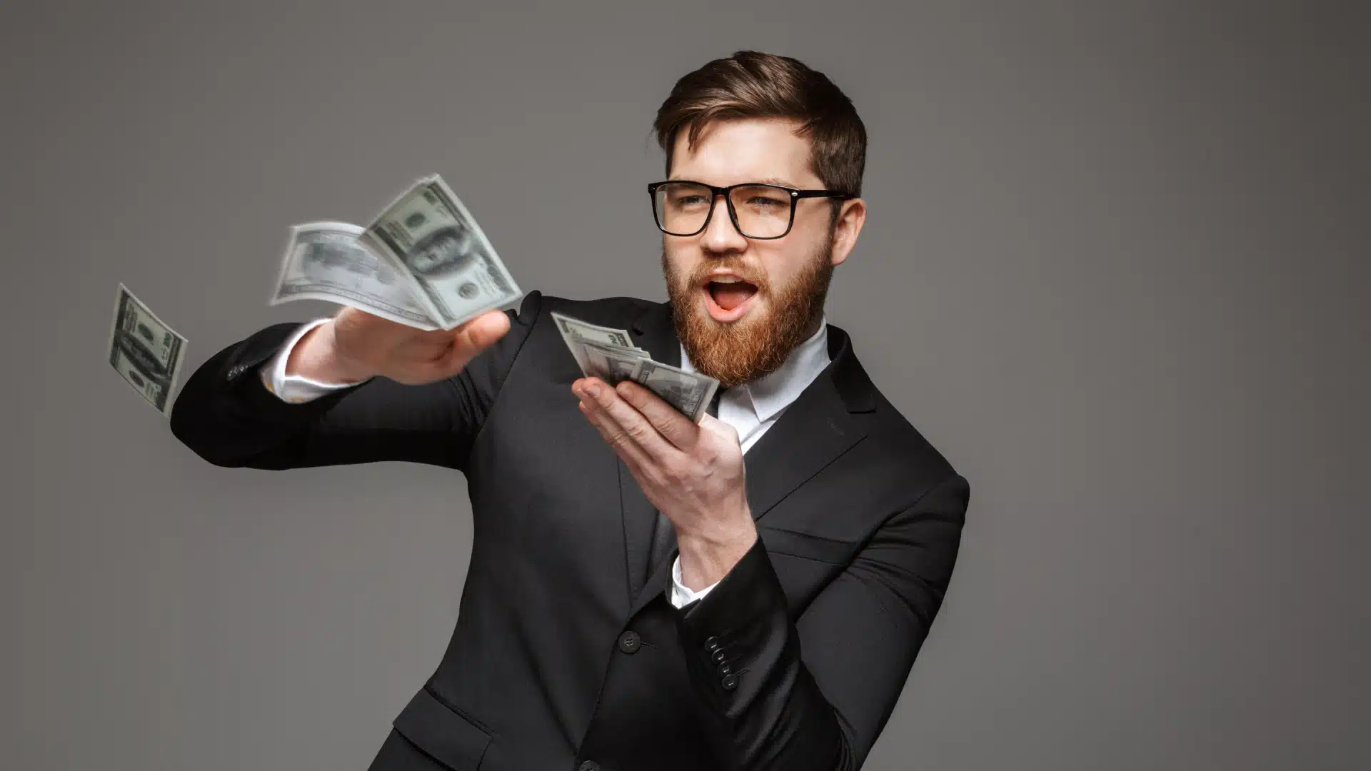 A man making it rain with a pile of money in his hand.