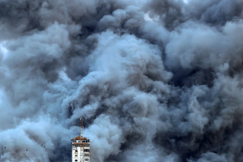 Smoke billows above Gaza City after an Israeli air strike hit the Palestine Tower building on October 7, 2023. — © AFP