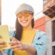 Happy Asian girl using mobile smartphone outdoor - Chinese social influencer having fun making video story for new trends social networks app - People, millennial generation and technology concept stock photo