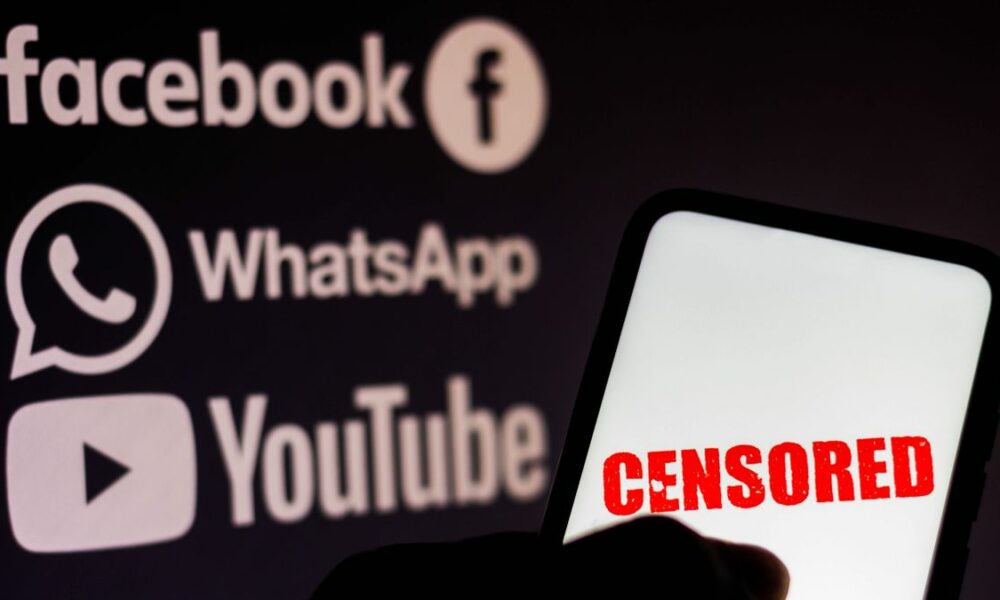 In this photo illustration the word censored is seen displayed on a smartphone with the logos of social networks Facebook, WhatsApp and YouTube in the background.