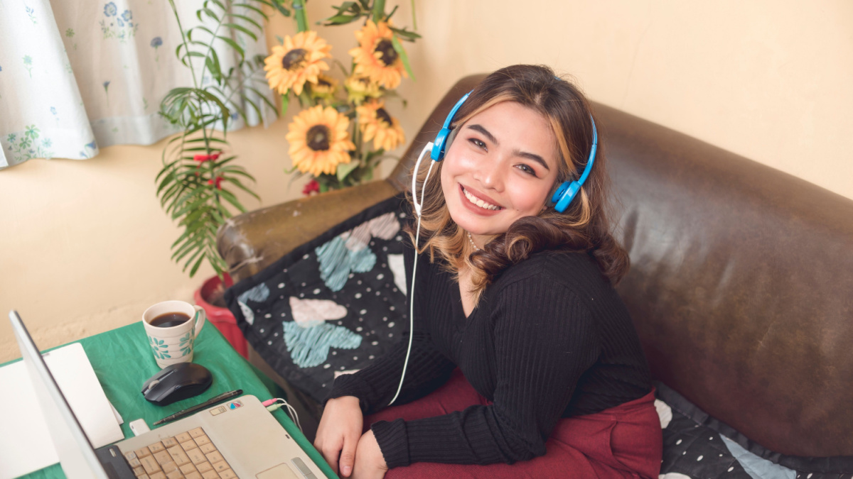 A freelance transcription agent smiling for a shot during her online meeting with her team for an event.