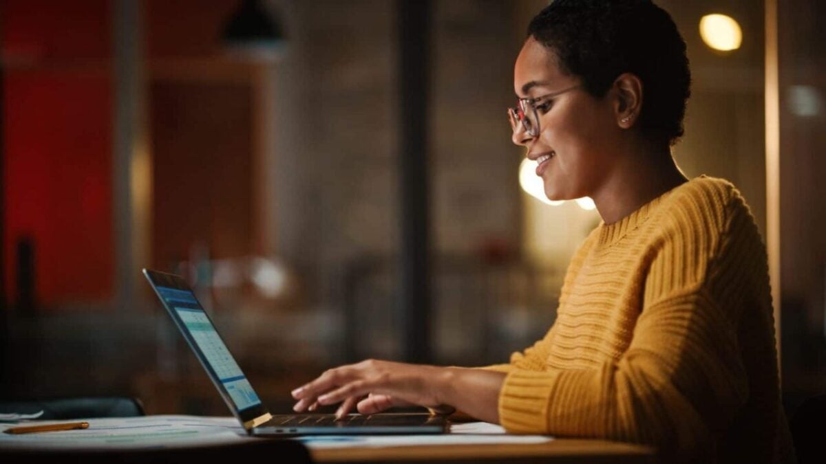 Young Multiethnic Developer Working on a Laptop Computer in Creative Office Environment. Beautiful Diverse Latin Female Project Manager is Developing Data and Scheduling a Project.