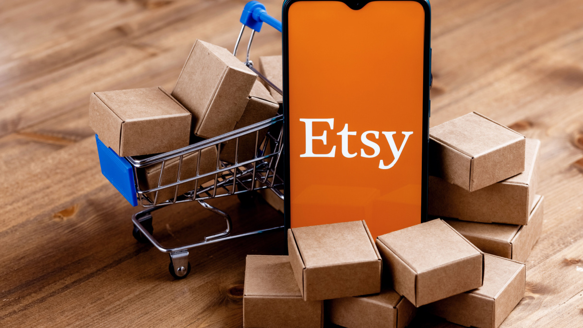 Kazan, Russia - Oct 6, 2021: Etsy is American e-commerce company focused on handmade items and craft supplies. Smartphone with Etsy logo on the screen, shopping cart and parcels.