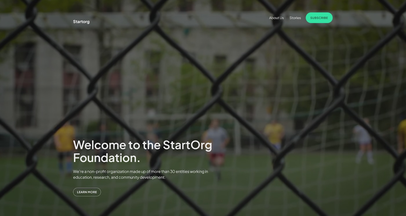 a screenshot of the StartOrg WordPress.com theme showcasing a photo taken through a fence of a soccer game and white text